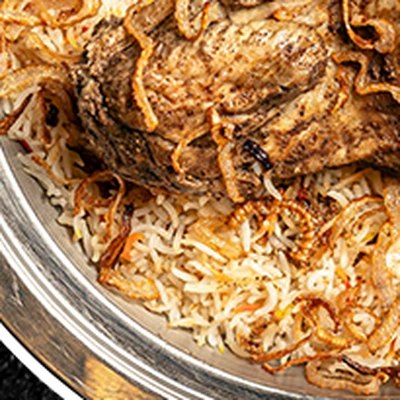 Biryani with spiced meat in a steel pot